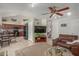 Open-concept living room with tile flooring, ceiling fan, and connecting kitchen and staircase at 6446 E Beverly Ln, Scottsdale, AZ 85254