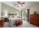Bright main bedroom features a ceiling fan, access to the outdoor balcony, and lovely cherry wood furniture at 6446 E Beverly Ln, Scottsdale, AZ 85254