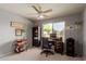 Well-lit office space with ceiling fan, desk, bookcase, and natural light from a large window overlooking backyard at 6446 E Beverly Ln, Scottsdale, AZ 85254