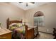 Cozy bedroom with a ceiling fan, window with pleated shades, and comfy bedding at 682 W Gum Tree Ave, Queen Creek, AZ 85140