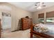 Cozy bedroom with a rustic wood bed frame, matching dresser, and a private ensuite bathroom at 682 W Gum Tree Ave, Queen Creek, AZ 85140