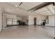 Spacious and organized three-car garage with ample storage space, workbench, and clean epoxy flooring at 682 W Gum Tree Ave, Queen Creek, AZ 85140