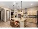 Spacious kitchen featuring a large island with granite countertop, stainless steel appliances, and modern lighting fixtures at 682 W Gum Tree Ave, Queen Creek, AZ 85140
