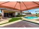 Inviting backyard with a sparkling pool, lush green lawn, covered patio, and ample space for outdoor entertaining at 682 W Gum Tree Ave, Queen Creek, AZ 85140