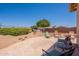 Relaxing backyard patio featuring stone pavers, lush greenery, and outdoor seating under a clear blue sky at 6931 S Four Peaks Way, Chandler, AZ 85249