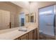 Bathroom featuring a long vanity with mirror, sink, tiled floors and a walk-in shower at 6931 S Four Peaks Way, Chandler, AZ 85249