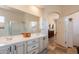 Primary bath featuring a double sink vanity with shower and opens to hallway and primary bedroom at 6931 S Four Peaks Way, Chandler, AZ 85249