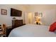 Bedroom featuring neutral walls, decor, door to hallway, and tv on bureau at 6931 S Four Peaks Way, Chandler, AZ 85249