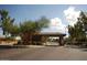 View of the community entrance, framed by mature desert landscaping at 6931 S Four Peaks Way, Chandler, AZ 85249