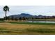 Scenic golf course view with lush green fairways, mature trees, pond and mountain backdrop at 6931 S Four Peaks Way, Chandler, AZ 85249