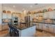 Open kitchen featuring custom cabinets, a central island with seating, and stainless steel appliances at 6931 S Four Peaks Way, Chandler, AZ 85249