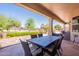 Charming outdoor dining and lounge area with garden views from the covered patio at 6931 S Four Peaks Way, Chandler, AZ 85249