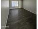 Open-concept living room with modern flooring, a large window, and a neutral color palette at 808 N 67Th Ln, Phoenix, AZ 85043