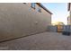 Pebbled backyard featuring an enclosed block wall, access gate, and view of the neighborhood at 822 E Agua Fria Ln, Avondale, AZ 85323