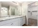Double vanity bathroom featuring granite countertops, white cabinetry, and views of the bedroom and closet at 822 E Agua Fria Ln, Avondale, AZ 85323