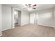 Neutral bedroom featuring an open en-suite bathroom, walk-in closet, carpet flooring, and a ceiling fan at 822 E Agua Fria Ln, Avondale, AZ 85323