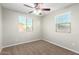 Bedroom featuring carpeted floors, a ceiling fan, and two windows at 822 E Agua Fria Ln, Avondale, AZ 85323