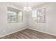 Cozy dining room with wood floors, bright chandelier and two windows with views of the outdoors at 822 E Agua Fria Ln, Avondale, AZ 85323