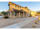 Inviting two-story home with desert landscaping, a covered porch, and a sidewalk leading to the entrance at 822 E Agua Fria Ln, Avondale, AZ 85323