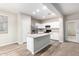Open kitchen area with stainless steel refrigerator, island, and seamless flow into the adjacent carpeted room at 822 E Agua Fria Ln, Avondale, AZ 85323