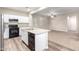 Modern kitchen island featuring a sink, dishwasher, black appliances, and an open view to the carpeted living area at 822 E Agua Fria Ln, Avondale, AZ 85323