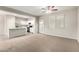 Bright living room with carpeted floors, white walls and trim, plus an adjacent kitchen with stainless appliances at 822 E Agua Fria Ln, Avondale, AZ 85323