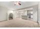 Spacious living area with a staircase, carpet, and adjacent kitchen featuring an island and stainless appliances at 822 E Agua Fria Ln, Avondale, AZ 85323