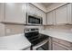 Stainless steel appliances in kitchen with black cooktop and granite countertops at 9151 W Greenway Rd # 162, Peoria, AZ 85381