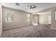 Expansive living room with neutral colors, carpet flooring, and sliding door leading to outdoor space at 917 E Agua Fria Ln, Avondale, AZ 85323