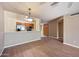 Open-concept living room with wood-look flooring, ceiling fan, and views into the kitchen at 9313 W Morrow Dr, Peoria, AZ 85382