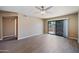 Open-concept living room featuring wood-look floors, a ceiling fan, and sliding glass door at 9313 W Morrow Dr, Peoria, AZ 85382