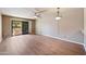 Spacious living room featuring wood-look floors, ceiling fan and sliding glass doors to the outside at 9313 W Morrow Dr, Peoria, AZ 85382