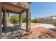 View of the backyard with the covered patio, desert landscaping and privacy fence at 10009 W Raymond St, Tolleson, AZ 85353