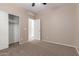 A comfortable bedroom featuring neutral walls, plush carpeting, ceiling fan, and access to a closet at 10009 W Raymond St, Tolleson, AZ 85353