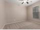 A light and airy bedroom featuring neutral walls, plush carpeting, ceiling fan, and a window for natural light at 10009 W Raymond St, Tolleson, AZ 85353