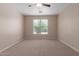 An inviting bedroom featuring neutral walls, plush carpeting, ceiling fan, and a window for natural light at 10009 W Raymond St, Tolleson, AZ 85353