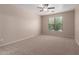 A light and airy bedroom featuring neutral walls, plush carpeting, ceiling fan, and a window for natural light at 10009 W Raymond St, Tolleson, AZ 85353
