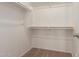 An organized walk-in closet, providing plenty of shelving and hanging space for wardrobe storage at 10009 W Raymond St, Tolleson, AZ 85353
