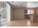 Bright kitchen with brown cabinets, tile flooring, a window with natural light, and access to the backyard at 10009 W Raymond St, Tolleson, AZ 85353