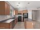 Functional kitchen featuring wood cabinets, an island, and black appliances at 10009 W Raymond St, Tolleson, AZ 85353