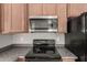 Close-up of modern stainless microwave and black electric stove at 10009 W Raymond St, Tolleson, AZ 85353