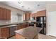 Kitchen featuring wood cabinets, tile floors, stainless dishwasher and black appliances at 10009 W Raymond St, Tolleson, AZ 85353