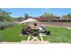 A beautiful backyard featuring a fireplace, manicured grass and lush colorful plants at 10152 E Phantom Way, Scottsdale, AZ 85255