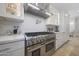 Modern kitchen featuring a stainless steel gas range, a tiled backsplash, and white cabinetry at 10152 E Phantom Way, Scottsdale, AZ 85255