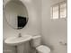 Clean half-bath with a round mirror, pedestal sink, and neutral color scheme at 10370 W Sands Dr # 463, Peoria, AZ 85383