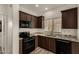 Well-lit kitchen featuring dark cabinets, granite countertops, and stainless steel appliances at 10370 W Sands Dr # 463, Peoria, AZ 85383