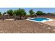 A sparkling pool surrounded by desert landscaping creates a tranquil backyard oasis at 10735 E Kilarea Ave, Mesa, AZ 85209