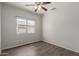This bedroom features light gray walls, wood-look floors, and a ceiling fan at 10735 E Kilarea Ave, Mesa, AZ 85209