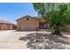 Single-story tan home featuring a two-car garage and manicured landscaping in a suburban neighborhood at 10735 E Kilarea Ave, Mesa, AZ 85209