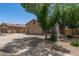 Single-story tan home featuring a two-car garage and manicured landscaping in a suburban neighborhood at 10735 E Kilarea Ave, Mesa, AZ 85209